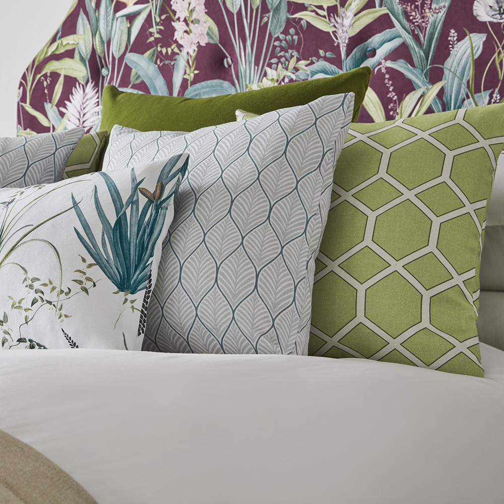 Exotic Garden collection upholstered to a headboard and displayed on 5 cushions sat on a bed